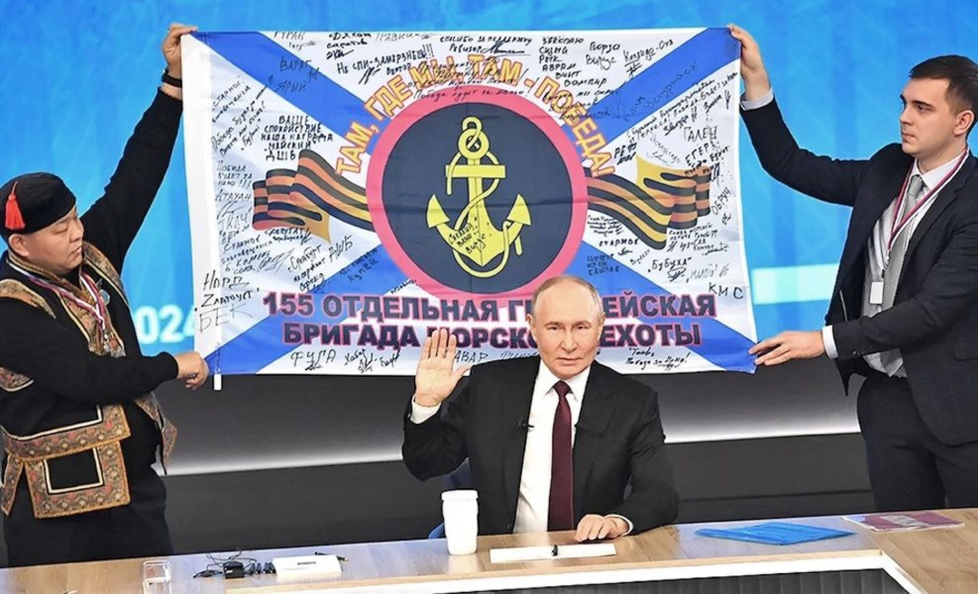 Владимир Путин на фоне подаренной бойцами копии боевого знамени 155-й гвардейской бригады морской пехоты